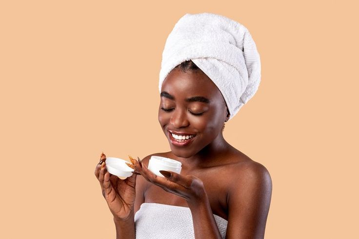 beautiful young african american woman holding bottle with cream